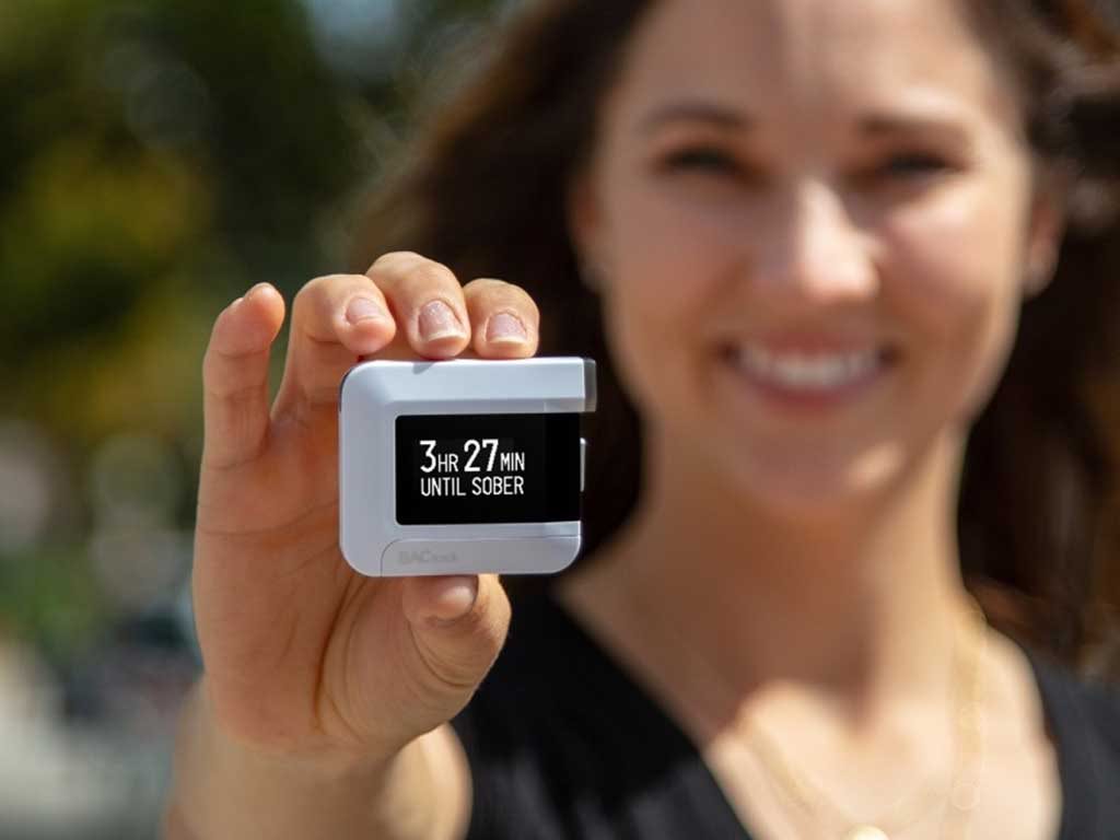 Woman showing BAC results from a mini breathalyser