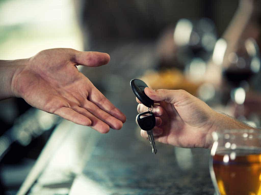 A person handing over his car keys to another person.