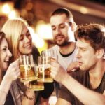 Four people drinking alcohol in a pub