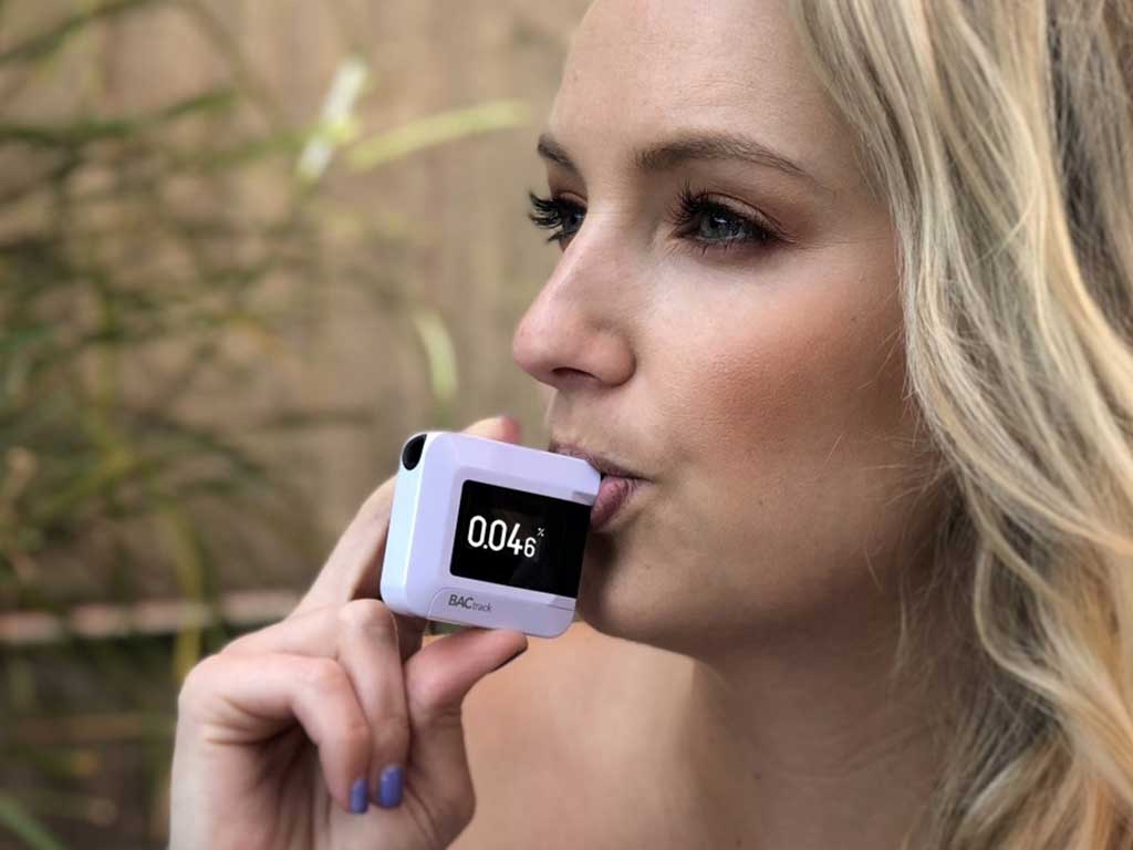 A woman blowing to a breathalsyer