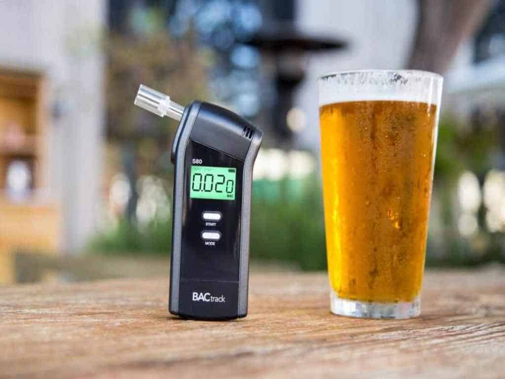 BACtrack S80 Pro breathalyzer beside a glass of beer