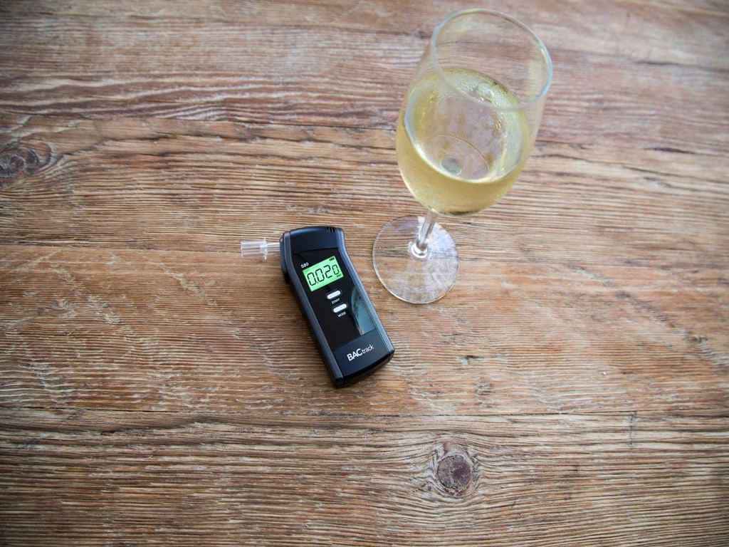 The BACtrack S80 Pro beside a glass of white wine