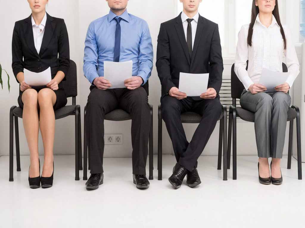 Four job applicants sitting while holding their resume