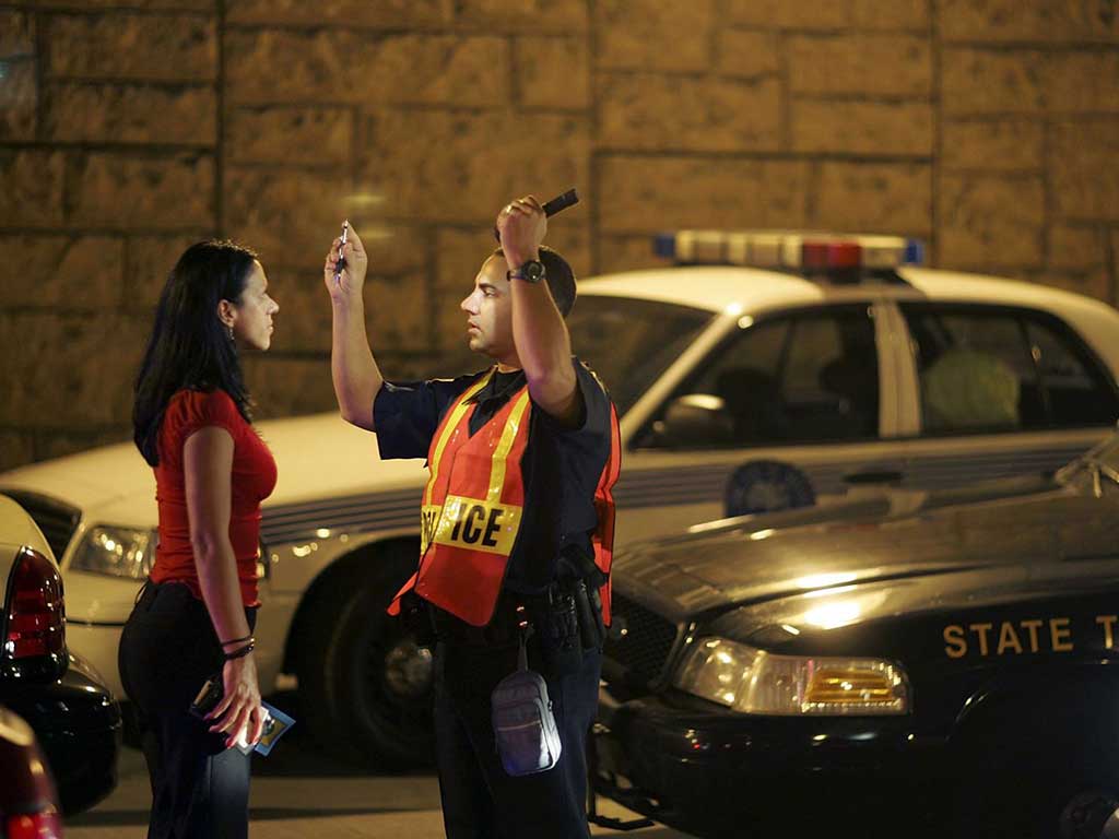 A police officer conducting a visual test on a female driver