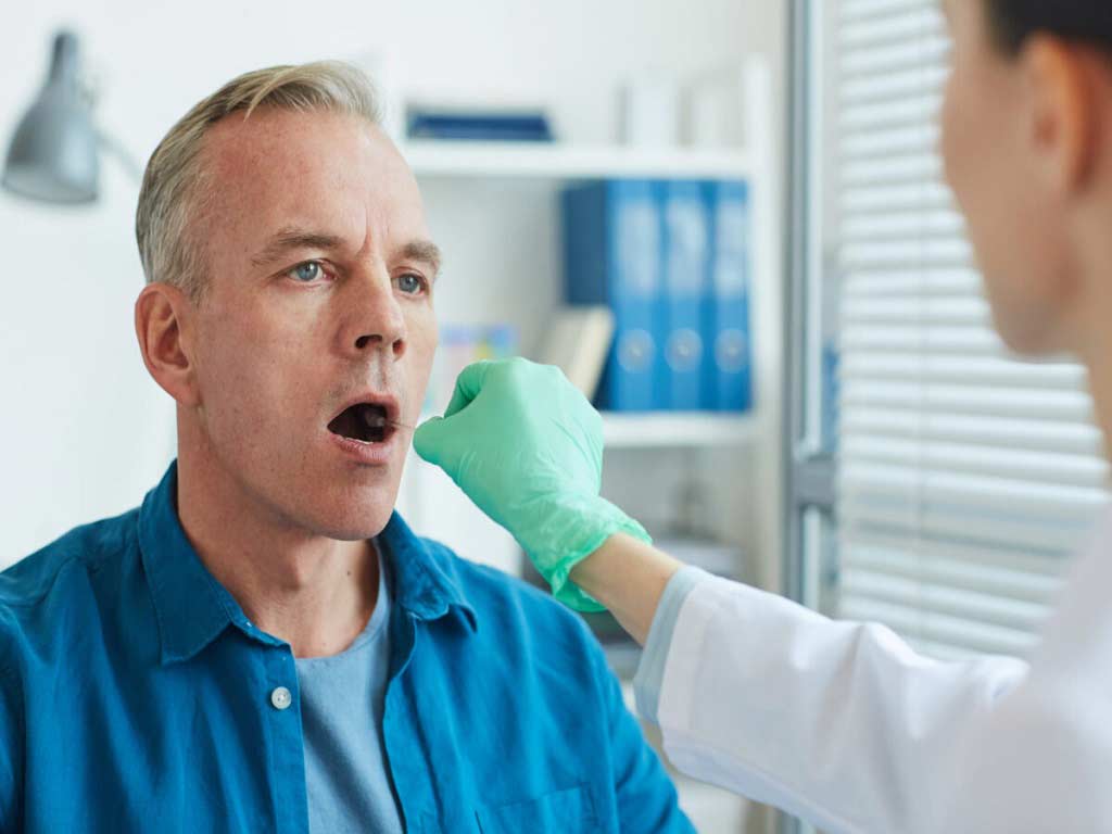 A man getting swabbed in the mouth at a clinic