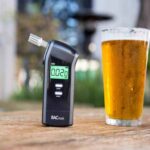 BACtrack breathalyser beside an alcoholic beverage