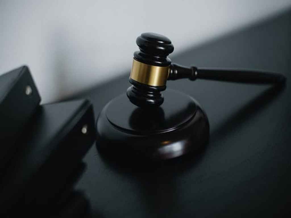 A black and gold gavel on top of a surface