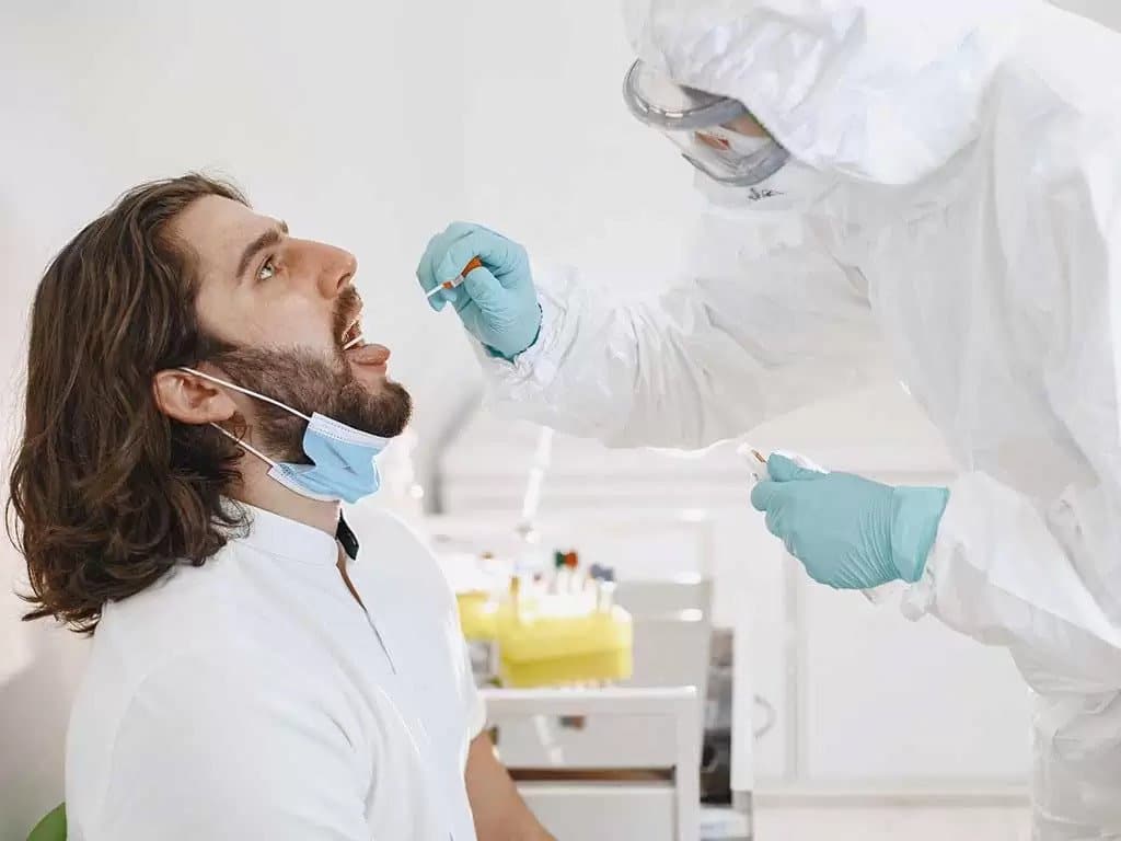 A technician swabbing a man in the mouth