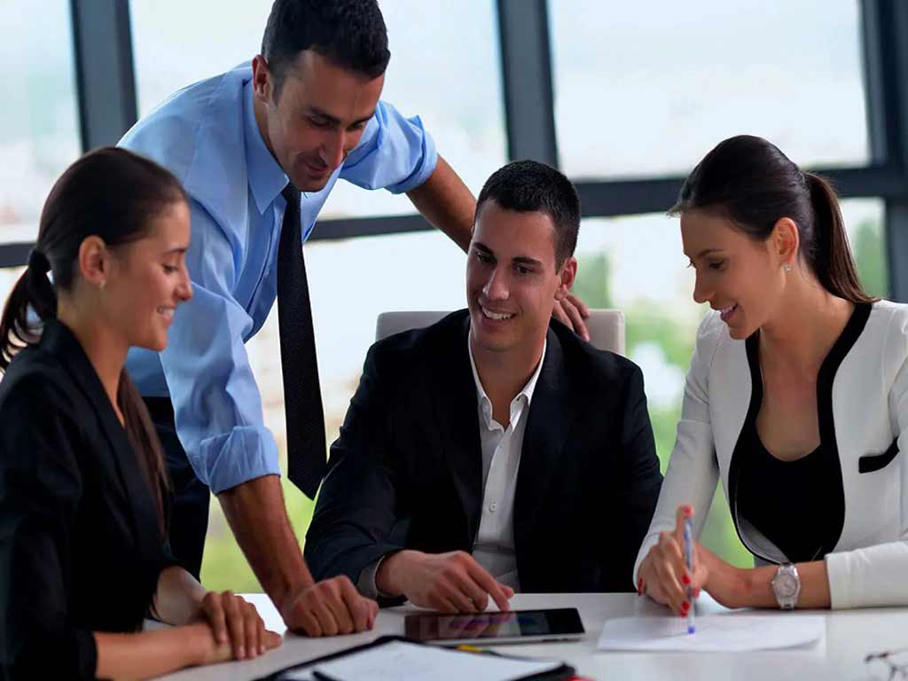 A team of professionals holds a discussion in a corporate environment.