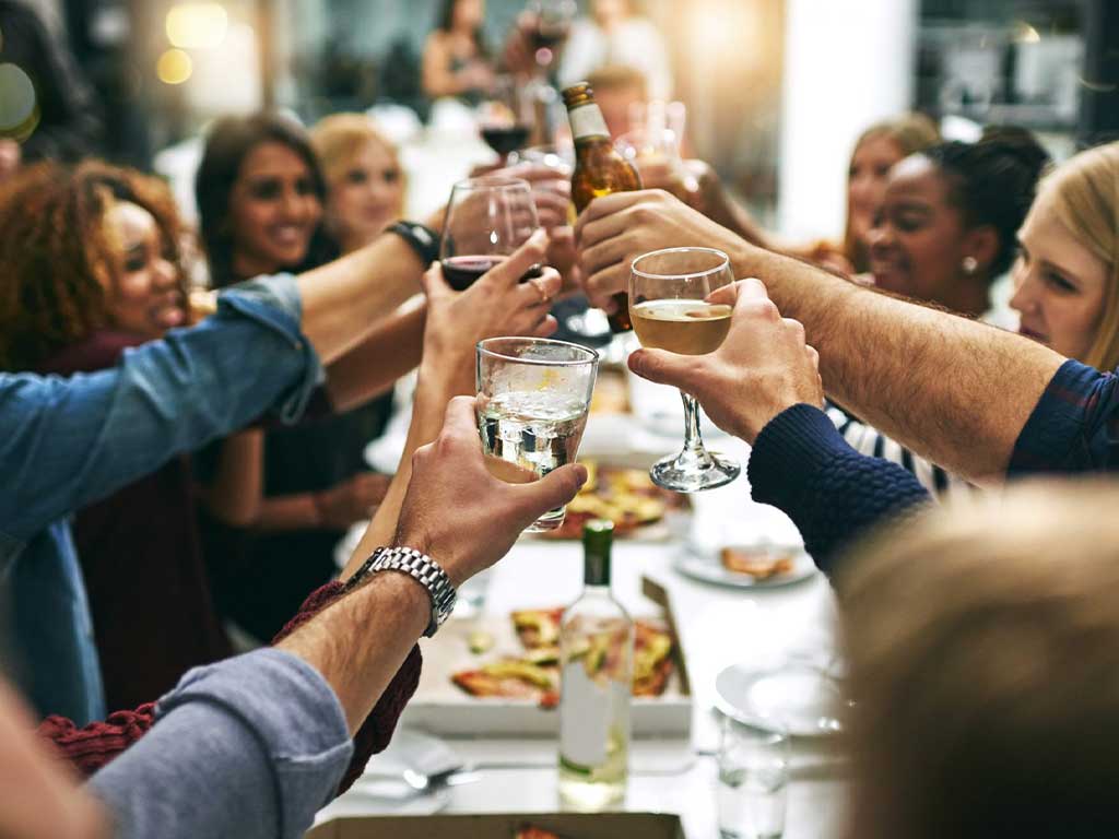 A group of people toasting to alcohol