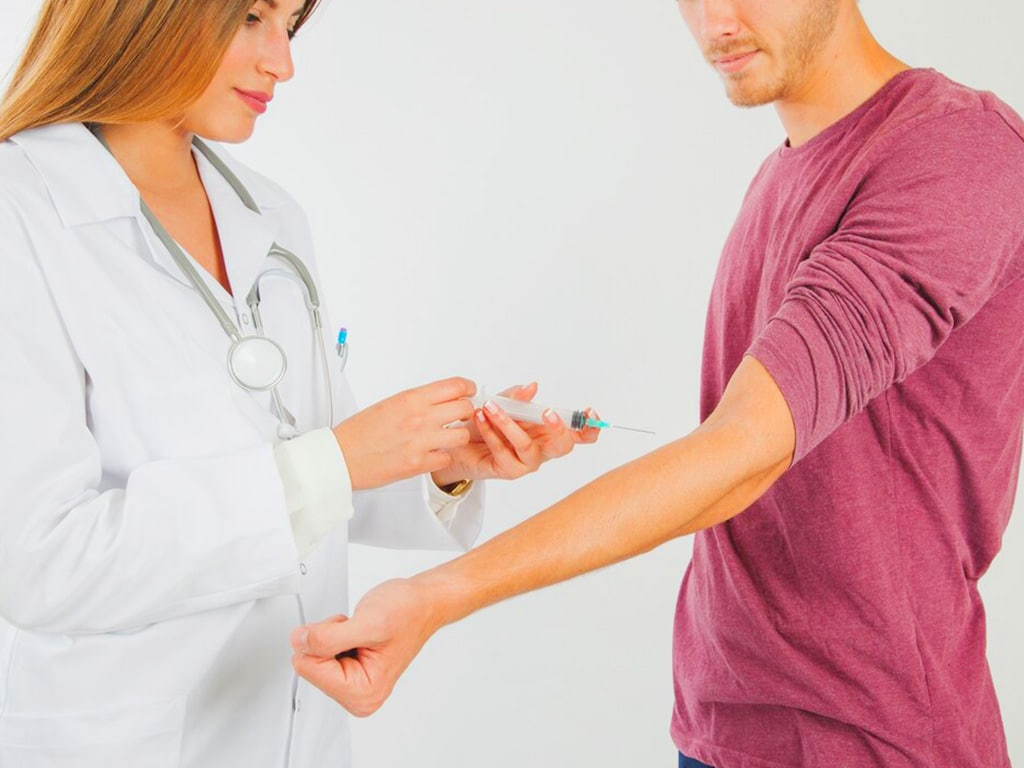 A medical professional about to draw blood from a man's arm