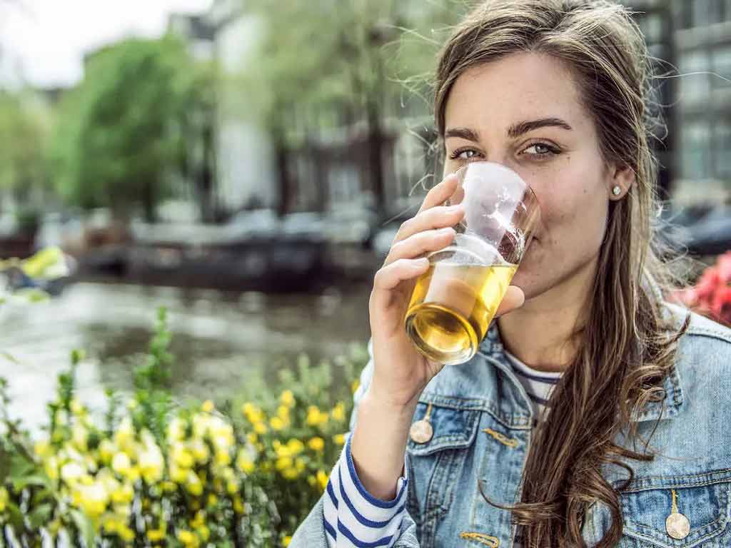 A woman drinking alcohol outside