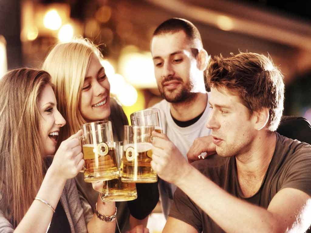 Four persons drinking alcohol in a bar