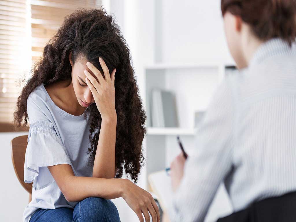 A worried woman talking to a counsellor