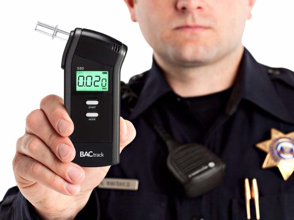 A police officer showing a breathalyzer