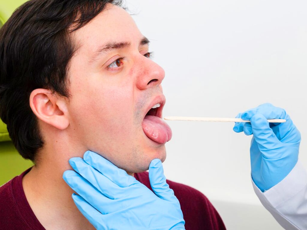 A trained collector gathering saliva samples from a male candidate