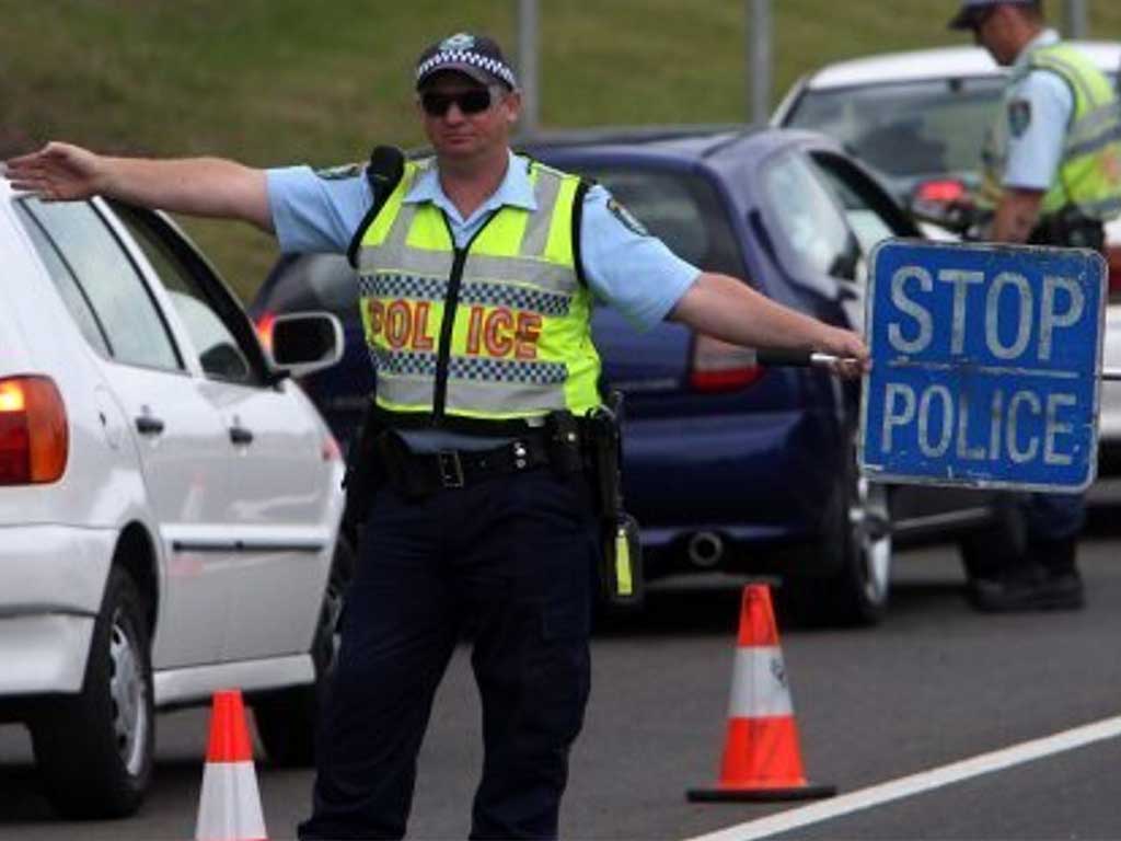 A police officer holding a stop sign for drug inspection