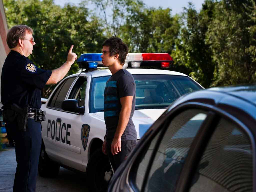An officer conducting a sobriety test to a male driver