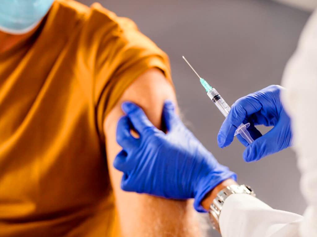 A medical professional about to use a needle to get blood samples