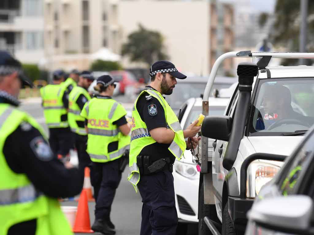 Police officers inspecting drivers on the side of the road