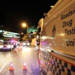 A roadside drug testing unit and officers stopping cars for a test