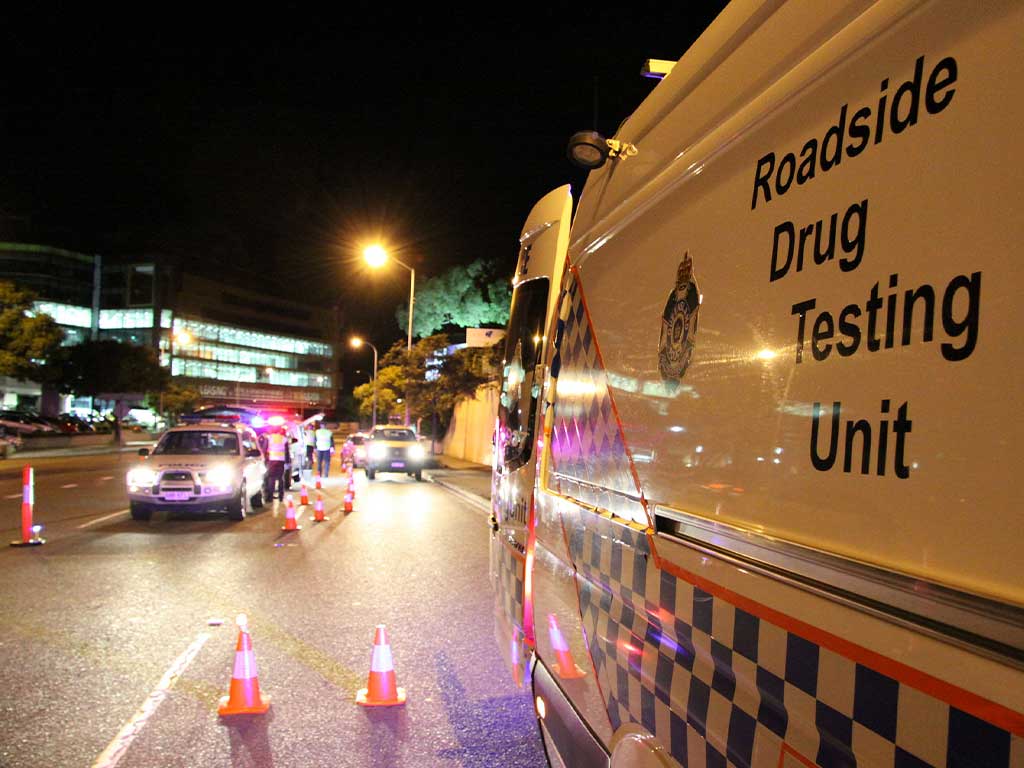 A roadside drug testing unit and officers stopping cars for a test