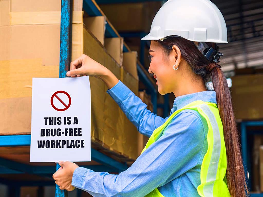 A lady engineer posting a drug-free workplace sign